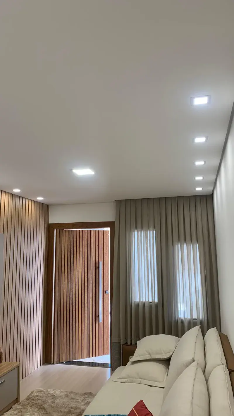 Sala com spots LED e painéis quadrados embutidos no teto falso